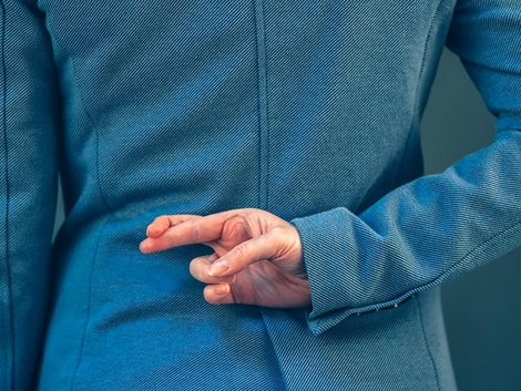 Wettbewerbsrecht, Makler, Herabsetzung von Mitbewerbern, unwahre Behauptungen, eine Hand mit zwei gekreuzten Fingern, Foto: iStock.com / stevanovicigor