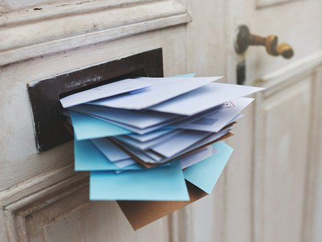 Wettbewerbsrecht, Makler, aufdringliches Anwerben, ein Briefeinwurf quillt über mit Post, Foto: iStock.com / PeopleImages