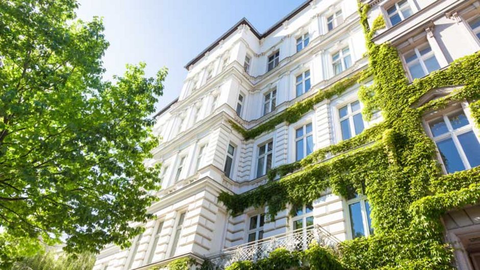 mieten oder kaufen, Bild eines Mehrfamilienhauses im Sonnenschein, Foto: Tiberius Gracchus / stock.adobe.com