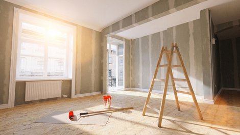 Mieterhöhung, Bild einer Wohnung mit nackten Wänden, einer Leiter und einer Farbrolle in der Mitte, Foto: iStock.com / rclassenlayouts