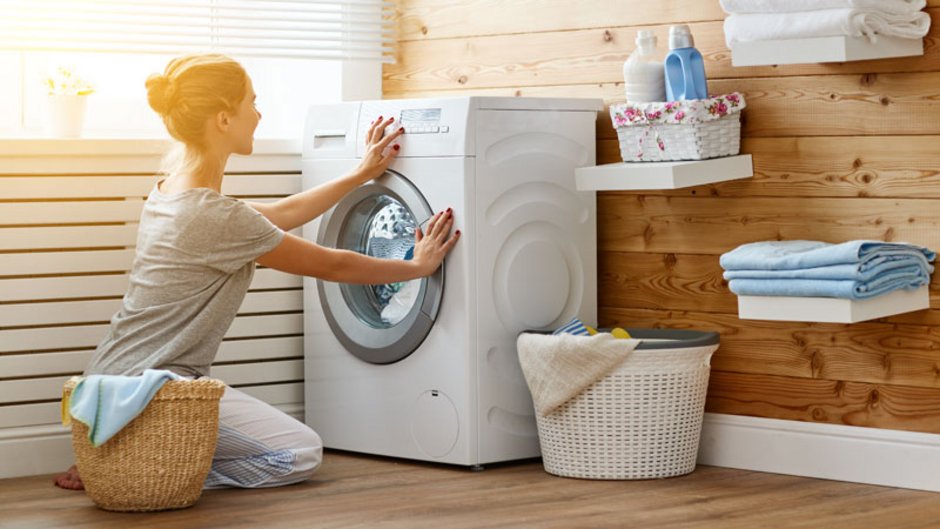 Energiesparen, Frau hockt vor einer Waschmaschine, Foto: JenkoAtaman/stock.adobe.com